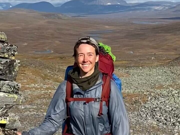 Kvinna på vandring ler mot kameran