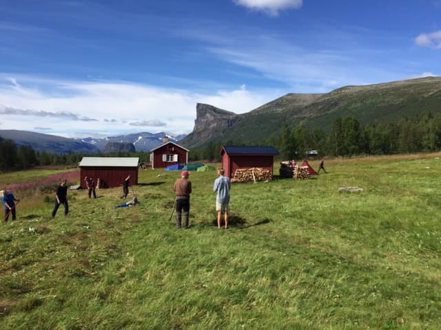 Aktsestugan med slagna ängar runt och med klippan Skierfe i bakgrunden
