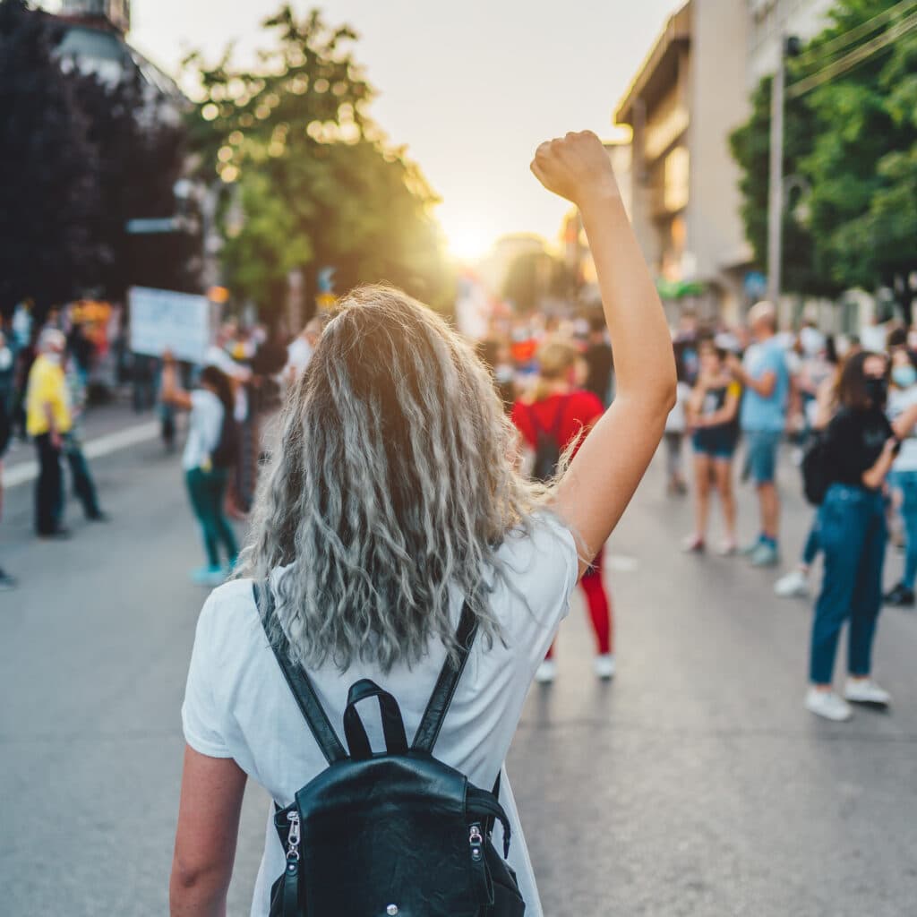 Young woman with a raised fist protesting in the street