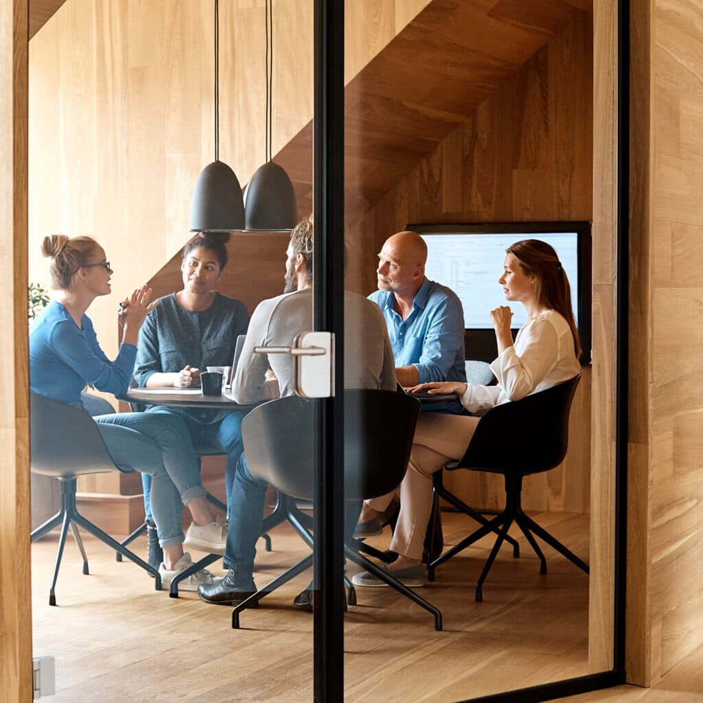 Grupp med människor i möte på kontor.