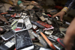 Workers sort through a pile of used mobile phones in New Delhi, India