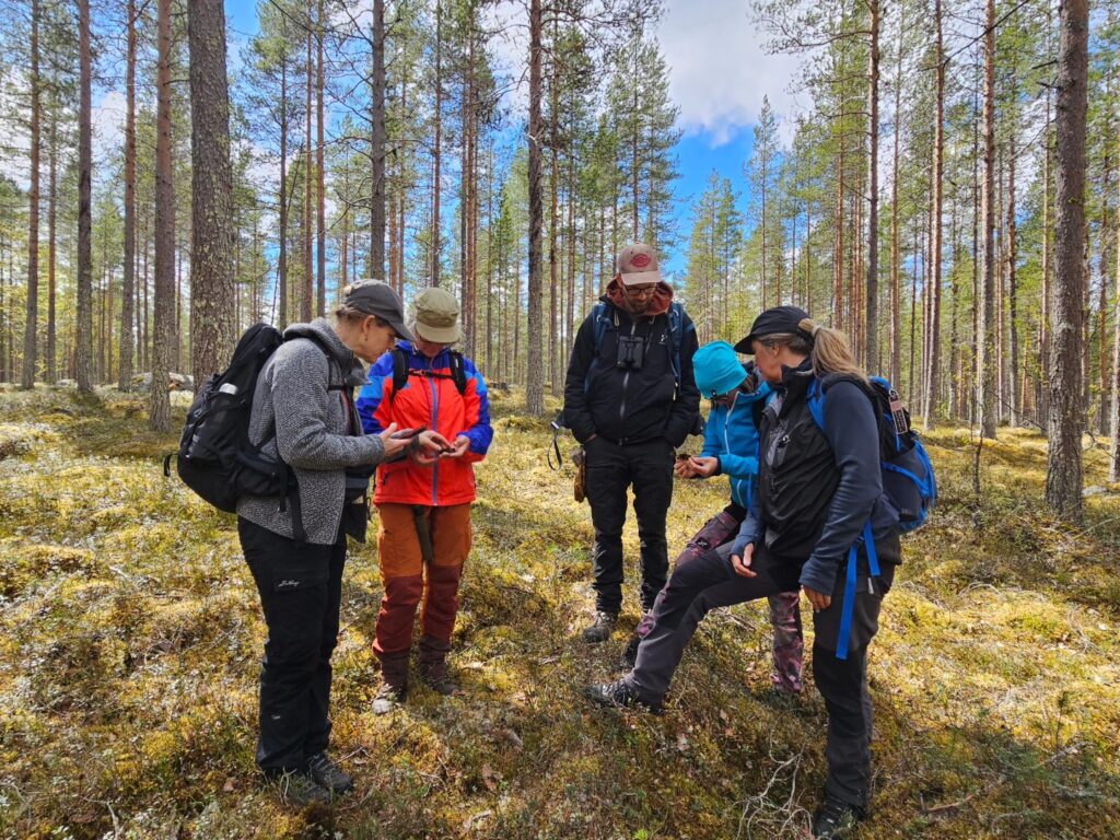 5 personer står i en ring i en skog