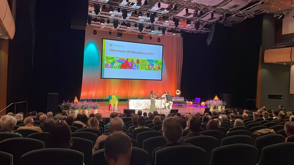 Scen med bild där det står "Välkommen till Riksstämma 2025"